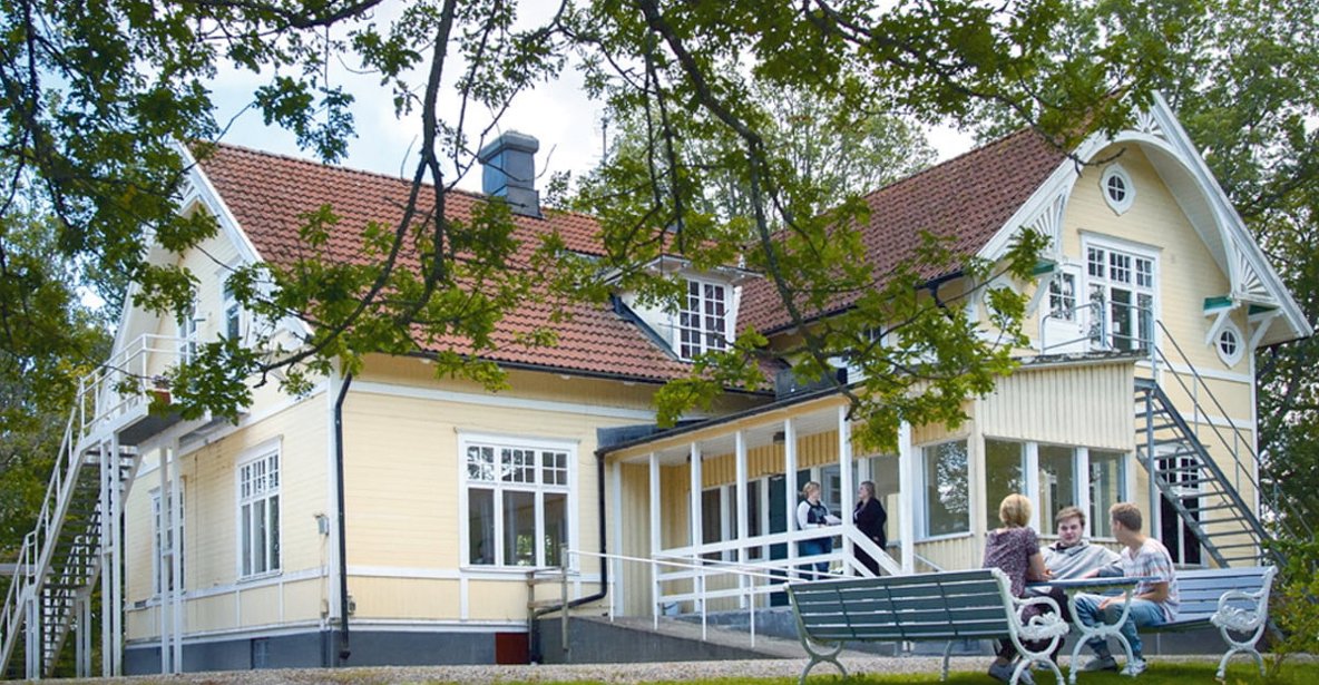 Ett stort gulmålat trähus med snickarglädje.