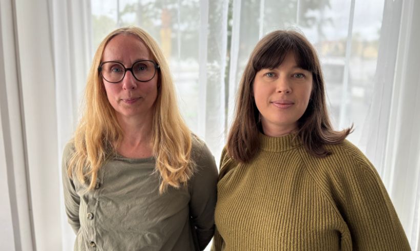 Två personer tittar in i kameran. 
