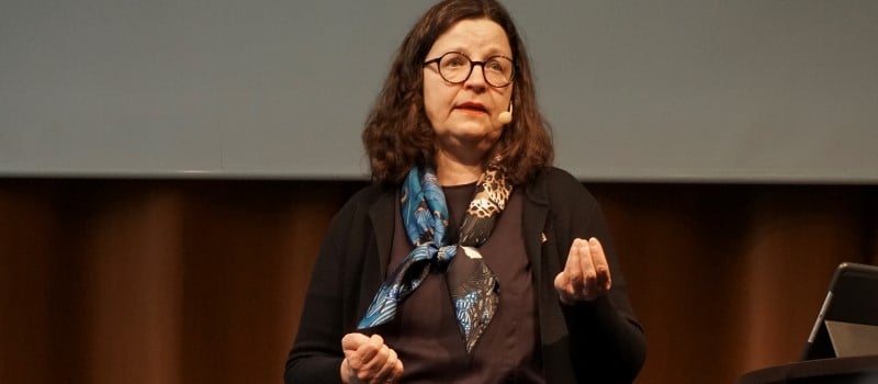 Kvinna talar på en scen.