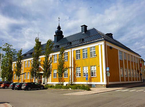 Bild: Sverigefinska folkh&ouml;gskolan, en gul tr&auml;byggnad vid Haparanda torg.