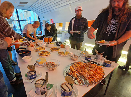 Bild: L&auml;rare och deltagare plockar mat fr&aring;n ett bord.